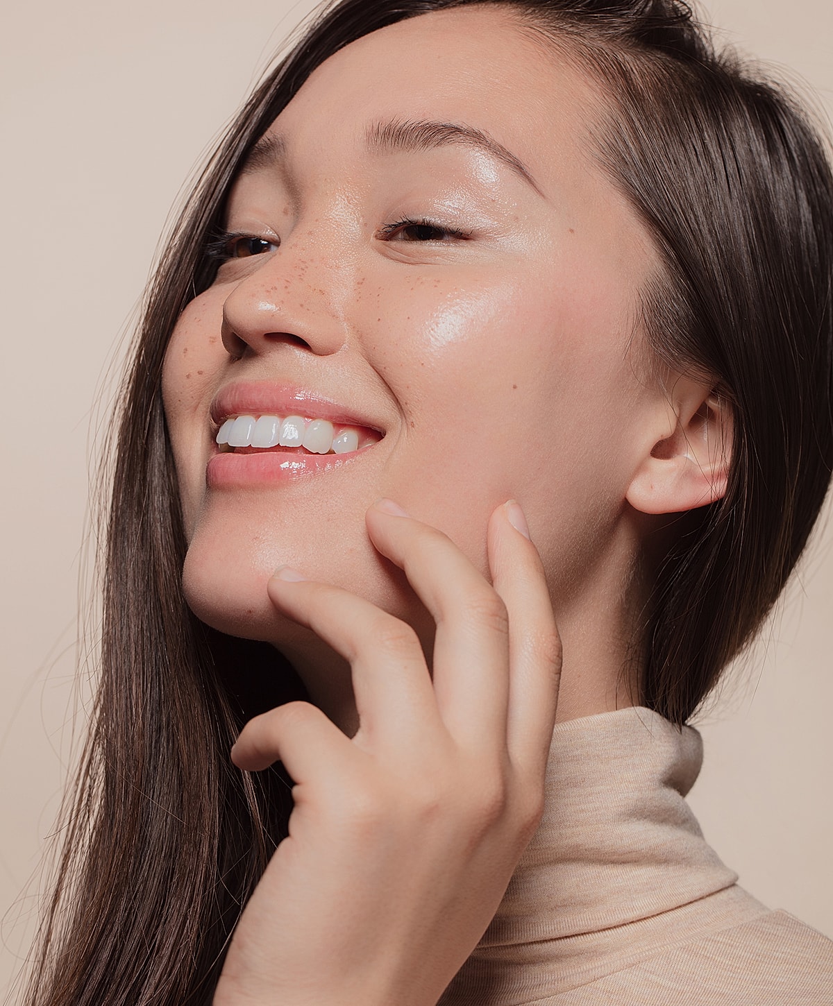 Smiling woman with long hair and radiant skin.