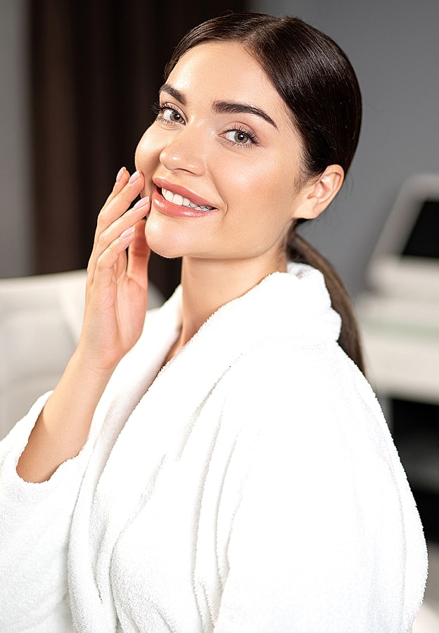 Smiling woman in white robe, natural beauty.