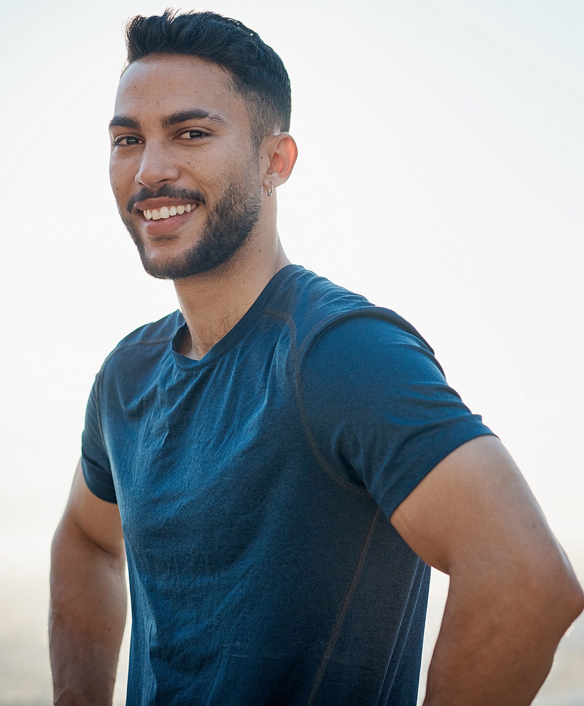 Smiling young man in casual blue shirt.